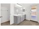 Bright bathroom featuring a double sink vanity, tiled floors, and a glass-panel door at 4723 W Samantha Way, Laveen, AZ 85339