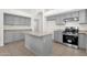 Neutral kitchen featuring gray cabinets, an island, stainless steel appliances, and tile flooring at 4723 W Samantha Way, Laveen, AZ 85339