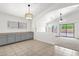 Open-concept kitchen and living room with gray cabinets, tile floors, and sliding glass doors at 4723 W Samantha Way, Laveen, AZ 85339
