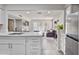 Open kitchen featuring white cabinets and quartz countertops, seamlessly flowing into the living room with a fireplace at 4901 S Calle Los Cerros Dr # 119, Tempe, AZ 85282
