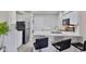 Modern kitchen featuring white cabinets, stainless steel appliances, breakfast bar seating, and a stackable washer/dryer at 4901 S Calle Los Cerros Dr # 119, Tempe, AZ 85282