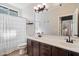 Neutral bathroom featuring double sinks, dark wood cabinets, and a shower with a white curtain at 5543 W Kowalsky Ln, Laveen, AZ 85339