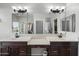 Primary bathroom featuring double sinks, dark wood cabinets, neutral walls, and a large framed mirror at 5543 W Kowalsky Ln, Laveen, AZ 85339