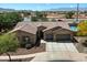 Aerial view of home showcasing a tile roof, three car garage, and professionally landscaped yard at 5543 W Kowalsky Ln, Laveen, AZ 85339