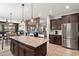 Open-concept kitchen with a central island, granite countertops, and modern appliances at 5543 W Kowalsky Ln, Laveen, AZ 85339