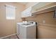Laundry room with white cabinets and modern washer and dryer at 5543 W Kowalsky Ln, Laveen, AZ 85339