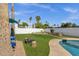 Well-maintained backyard featuring lush green grass, palm trees, a fire pit, and access to the refreshing pool at 6401 E Voltaire Ave, Scottsdale, AZ 85254