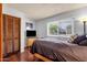 Bedroom showcasing wood floors, a dresser, and a window with blinds at 6401 E Voltaire Ave, Scottsdale, AZ 85254