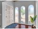 Foyer with tile trimmed wood floors, arched windows, and white walls at 6401 E Voltaire Ave, Scottsdale, AZ 85254