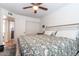 Cozy bedroom with a ceiling fan, neutral walls, and a door leading to the bathroom at 6501 W Columbus Ave, Phoenix, AZ 85033