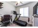 Bright bedroom featuring a treadmill, desk, chair and natural light at 6501 W Columbus Ave, Phoenix, AZ 85033