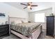 Bedroom featuring a comfortable bed with floral patterned bedding, ceiling fan, and neutral walls at 6501 W Columbus Ave, Phoenix, AZ 85033