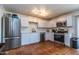 Bright kitchen featuring white cabinets, stainless steel appliances, and terracotta-style floors at 6501 W Columbus Ave, Phoenix, AZ 85033