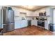 Bright kitchen featuring stainless steel appliances, white cabinetry, tile backsplash, and terra cotta tile flooring at 6501 W Columbus Ave, Phoenix, AZ 85033