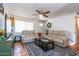 Cozy living room featuring comfortable seating, ceiling fan, and a patterned rug over tile flooring at 6501 W Columbus Ave, Phoenix, AZ 85033