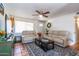 Cozy living room featuring neutral couches, a ceiling fan, and a stylish rug with colorful flowers adding a touch of charm at 6501 W Columbus Ave, Phoenix, AZ 85033