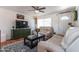 Cozy living room featuring comfortable seating, TV, ceiling fan, and a patterned rug over tile flooring at 6501 W Columbus Ave, Phoenix, AZ 85033