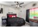 Comfortable room featuring a bed, ceiling fan and window at 6701 W Catalina Dr, Phoenix, AZ 85033