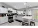 Bright kitchen featuring white cabinetry, stainless steel appliances, and a breakfast bar at 6701 W Catalina Dr, Phoenix, AZ 85033