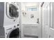 Bright laundry room featuring stacked washer and dryer and ample storage cabinets at 6701 W Catalina Dr, Phoenix, AZ 85033