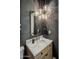 Elegant powder room featuring marble countertop, unique lighting fixture, and sophisticated gray textured wallpaper at 7327 E La Junta Rd, Scottsdale, AZ 85255