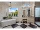 Serene bathroom featuring a soaking tub, large window, and black and white tile floors at 7327 E La Junta Rd, Scottsdale, AZ 85255