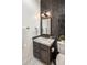 Modern bathroom featuring a vanity with marble countertop, black tiled wall, and herringbone tile flooring at 7327 E La Junta Rd, Scottsdale, AZ 85255