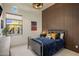 Cozy bedroom with a metal bed frame, wood paneled wall, and bright natural light at 7327 E La Junta Rd, Scottsdale, AZ 85255