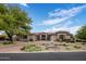 Stunning front exterior with mature landscaping, a circular driveway, and a beautiful water fountain at 7327 E La Junta Rd, Scottsdale, AZ 85255