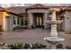 Elegant home with arched entryway, mature landscaping, and statement fountain feature at 7327 E La Junta Rd, Scottsdale, AZ 85255
