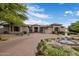 Beautiful front exterior features lush landscaping, a water fountain, and a circular driveway at 7327 E La Junta Rd, Scottsdale, AZ 85255