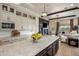 Open-concept kitchen and living room with a large island, custom cabinets, and a fireplace at 7327 E La Junta Rd, Scottsdale, AZ 85255