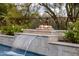 A resort-style pool includes a cascading waterfall feature, a fire pit, and lush landscaping at 7327 E La Junta Rd, Scottsdale, AZ 85255