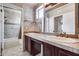 Bathroom featuring double sinks with dark wood cabinets and tile backsplash with decorative mosaic at 8225 N Central Ave # 44, Phoenix, AZ 85020
