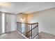 Well-lit hallway featuring neutral colored carpet and walls, leading to bedroom, with a stairwell at 8225 N Central Ave # 44, Phoenix, AZ 85020