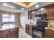 Bright kitchen with granite countertops, dark wood cabinets, and modern black appliances at 8225 N Central Ave # 44, Phoenix, AZ 85020