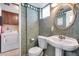 Charming powder room with pedestal sink, decorative wallpaper, and a glimpse into the laundry area at 8225 N Central Ave # 44, Phoenix, AZ 85020
