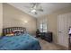 Cozy bedroom features a ceiling fan, blue bedding, and window with natural light at 843 E Vera Ln, Tempe, AZ 85284