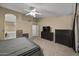 Bright main bedroom with ensuite bathroom, fan, and plush carpeting at 843 E Vera Ln, Tempe, AZ 85284