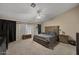 Cozy main bedroom features an en-suite bathroom, fan, and plush carpeting at 843 E Vera Ln, Tempe, AZ 85284