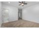Spacious bedroom with carpet and ceiling fan, with a view of the bathroom and walk-in closet at 8679 W Raven Dr, Arizona City, AZ 85123