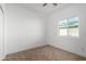 Bright bedroom with a window offering outside views and neutral carpeted floor at 8679 W Raven Dr, Arizona City, AZ 85123