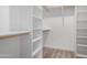 Walk-in closet featuring ample shelving space and wooden rods for clothes, providing functional storage solutions at 8679 W Raven Dr, Arizona City, AZ 85123