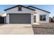 Charming single-story home featuring gray 2-car garage, gravel landscaping, and modern design at 8679 W Raven Dr, Arizona City, AZ 85123