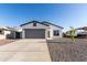 Charming single-story home featuring gray 2-car garage, gravel landscaping, and modern design at 8679 W Raven Dr, Arizona City, AZ 85123