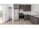 Well-equipped kitchen featuring stainless steel appliances, pantry, wood cabinets, and wood-look floors at 8679 W Raven Dr, Arizona City, AZ 85123