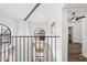 Hallway view with metal railing, arched windows, and doorway to a bedroom at 8844 S 51St St # 3, Phoenix, AZ 85044