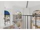Bright landing with wood floors, iron railing, and large arched windows showcasing the neighborhood at 8844 S 51St St # 3, Phoenix, AZ 85044