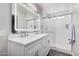 Bright bathroom with dual sinks, modern mirror, and tiled shower with glass door at 924 E Baylor Ln, Gilbert, AZ 85296