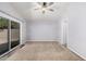 A spacious bedroom with neutral carpet, ceiling fan, and sliding glass door to backyard at 924 E Baylor Ln, Gilbert, AZ 85296